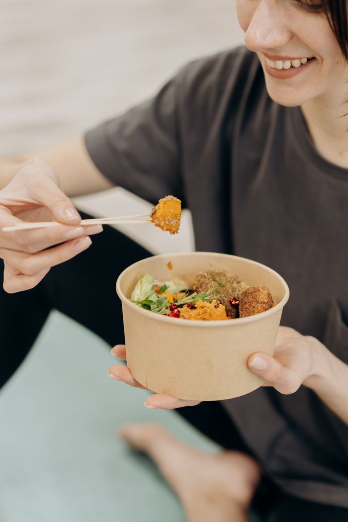 Woman enjoying a nutritious rice bowl with chopsticks